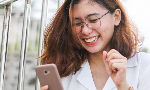 Woman holding cell phone for free phone consultation for counseling services.